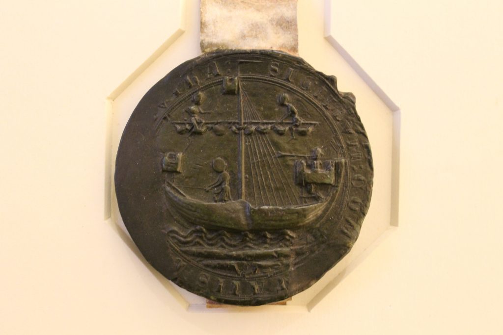 green wax seal showing ship and three sailors