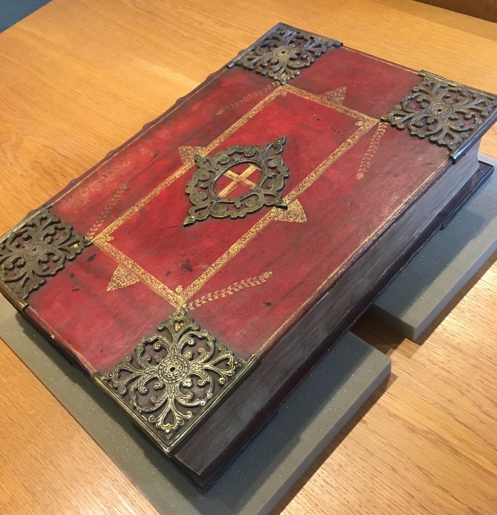 Ornate red and gold leather binding with brass decorations