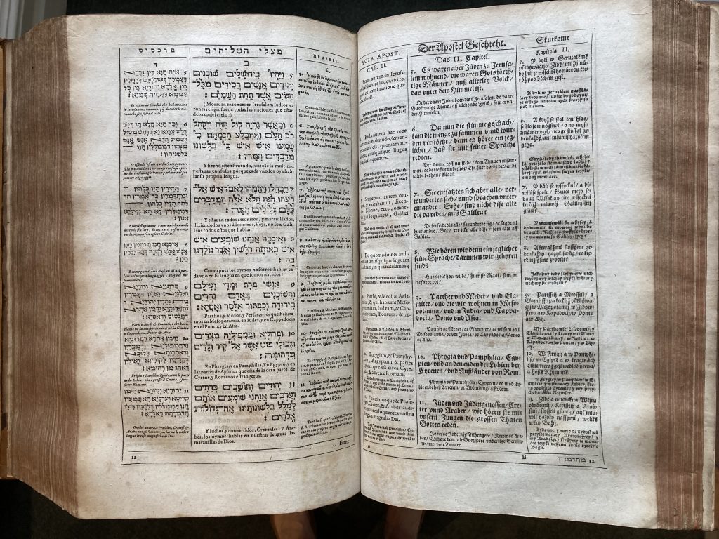 A double-page spread from a printed book. The text is in twelve different languages, each printed in a different type face and size. The page is arranged in six columns with two languages alternating in each column. It is printed in black ink on off-white paper.